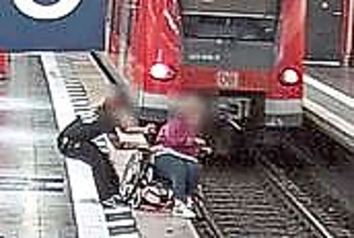 Das Bild einer Überwachungskamera zeigt, wie Jürgen Hermann die Rollstuhlfahrerin im Münchner Hauptbahnhof vor dem Absturz bewahrt.