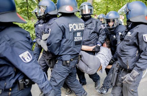 Polizisten tragen bei einer Kundgebung gegen die Corona-Beschränkungen auf der Straße des 17. Juni einen Mann. Foto: dpa/Christoph Soeder