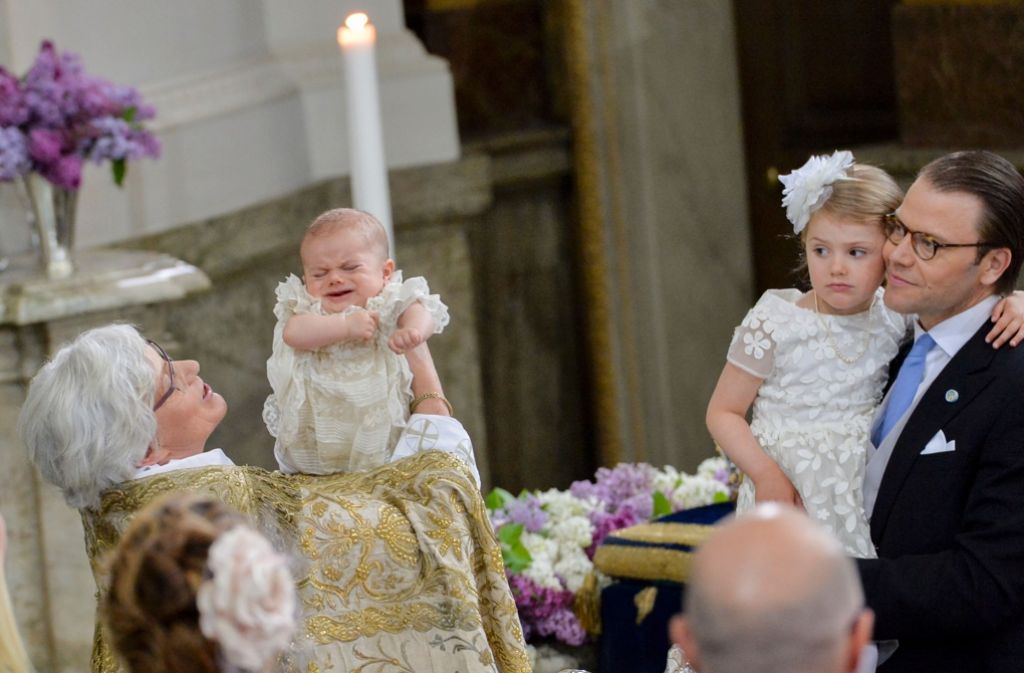 Die vierjährige Estelle (zweite von rechts) scheint mit ihrem Bruder mitzuleiden: Bei seiner Taufe hat sich Prinz Oscar von Schweden dann doch ein paar Tränchen nicht verdrücken können. Foto: AFP
