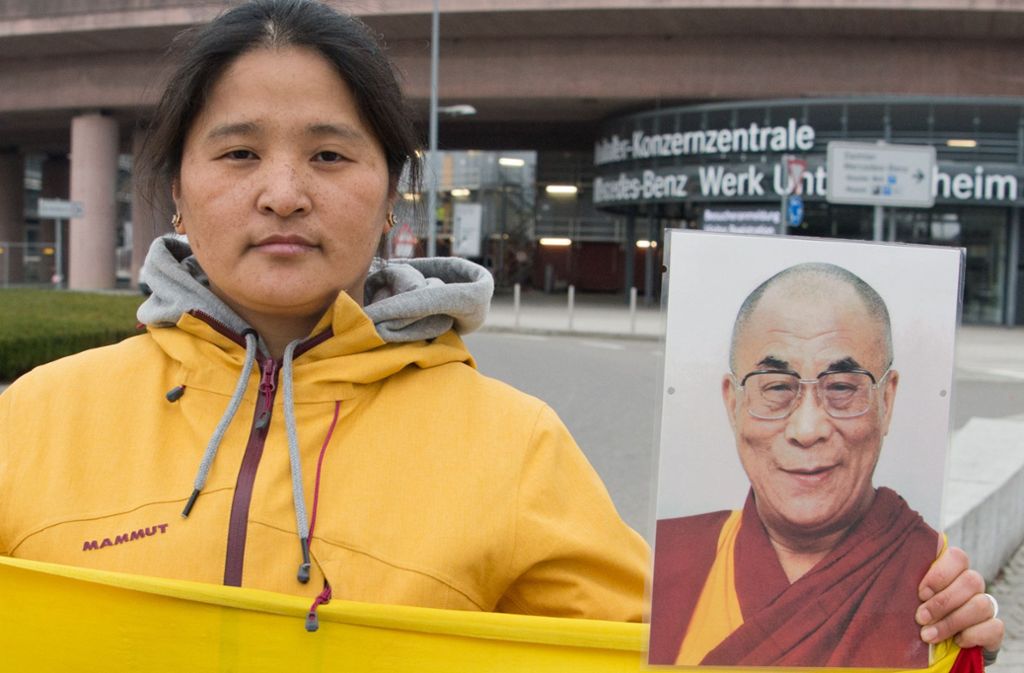 Eine Demonstrantin hält ein Bild des Dalai Lama hoch.