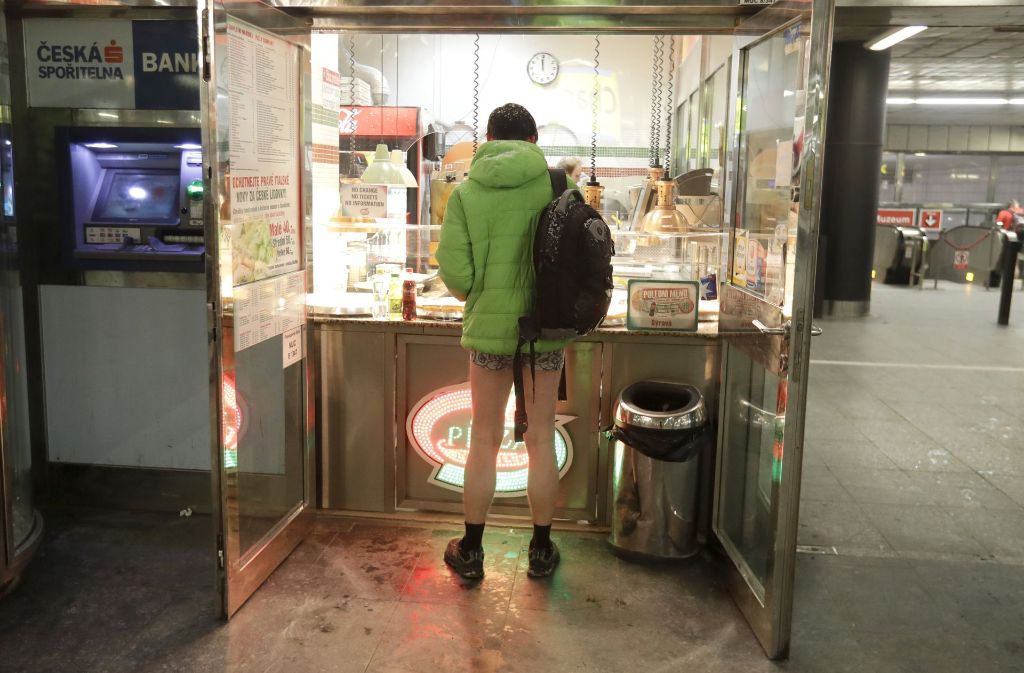 Ein Fahrgäste kauft ein Stück Pizza während er in der U-Bahn in Prag (Tschechien) am „No Pants Subway Ride“ teilnimmt.