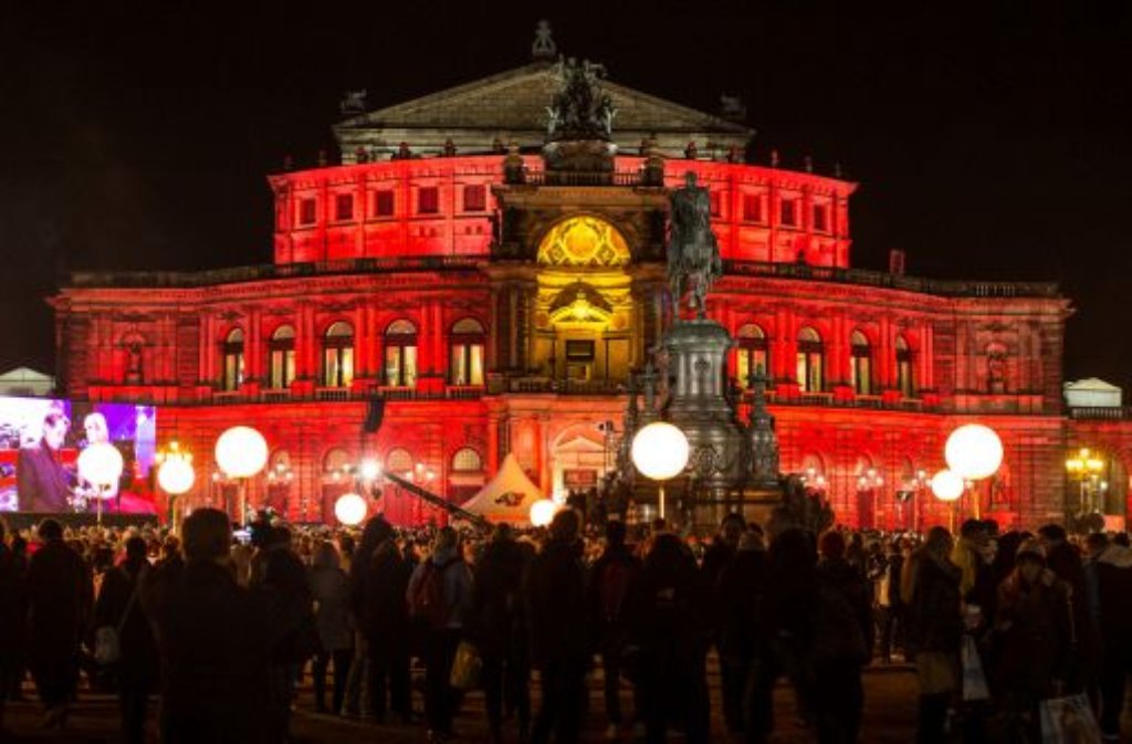 Theaterplatz vor der Kulisse der bunt angestrahlten Semperoper in Dresden.