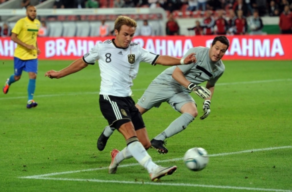 Deutschlands Mario Goetze (M) schießt am 10.08.2011 ein Tor im Länderspiel Deutschland gegen Brasiliens Torwart Julio Cesar in Stuttgart (Baden-Württemberg).