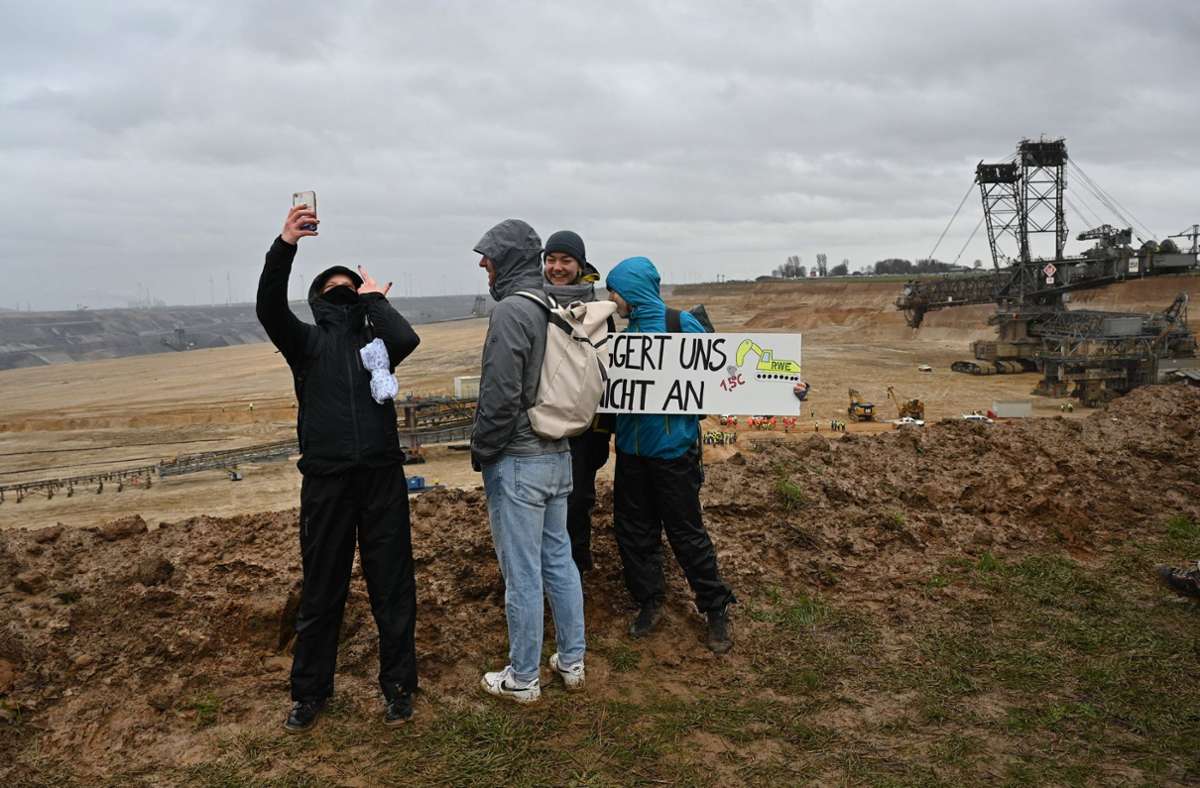 „Baggert uns nicht an“ steht auf dem Schild, das Demonstranten vor dem Tagebau halten.