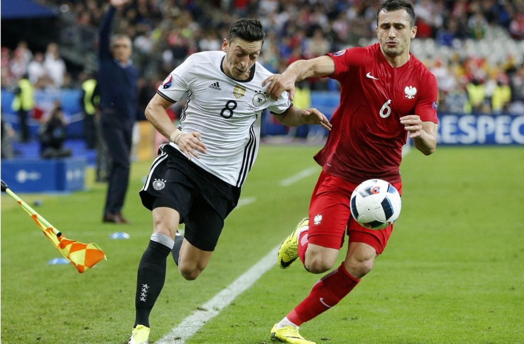 Selten dem Gegner entwischt: Mesut Özil (li.) gegen Polens Tomasz Jodlowiecs Foto: AP