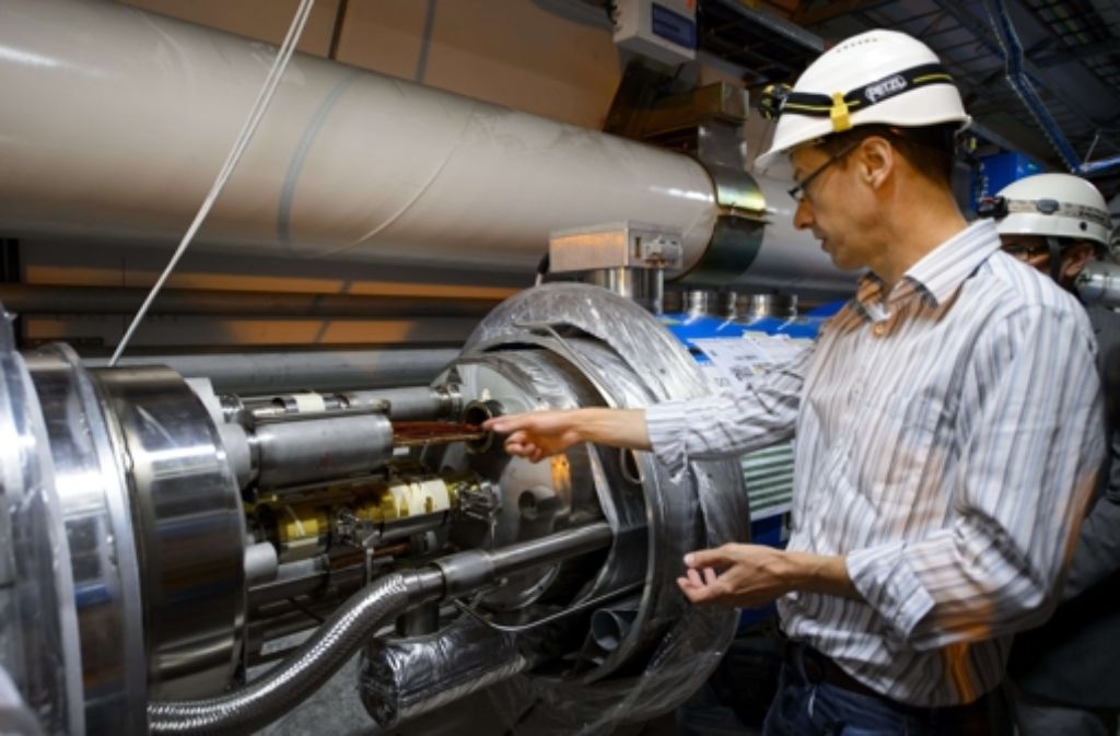 Ein Mitarbeiter des Cern wartet das dicke Rohr des Teilchenbeschleunigers LHC. Die Teilchen fliegen in zwei dünnen Rohren in der Mitte, die hier nicht sichtbar sind. Der Rest ist Kühlung, Abschirmung und Elektronik. Zudem gibt es im Tunnel des LHC viele Magnete, die die Teilchen auf Kurs halten.