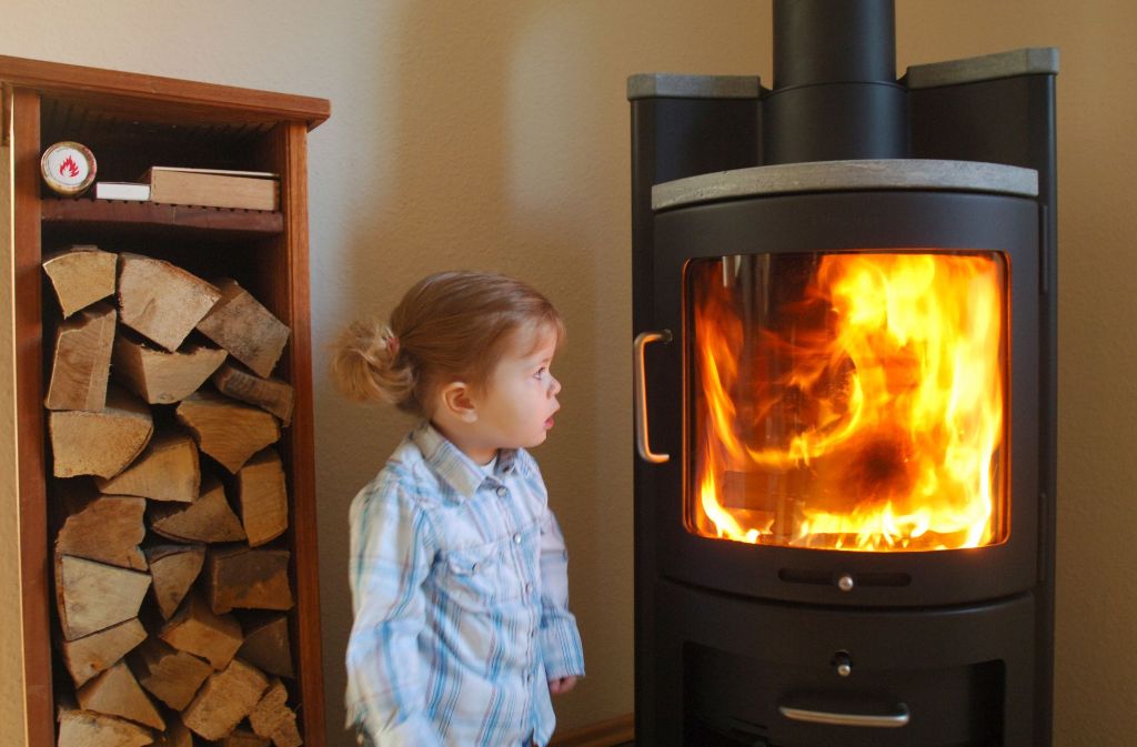Die 19 Monate alte Friederike schaut  staunend in die Flammen eines mit Buchenholz befeuerten Kaminofens. Was sie wohl nicht weiß: Wenn das Feuer nicht gut brennt, entstehen viele Schadstoffe. Foto: dpa