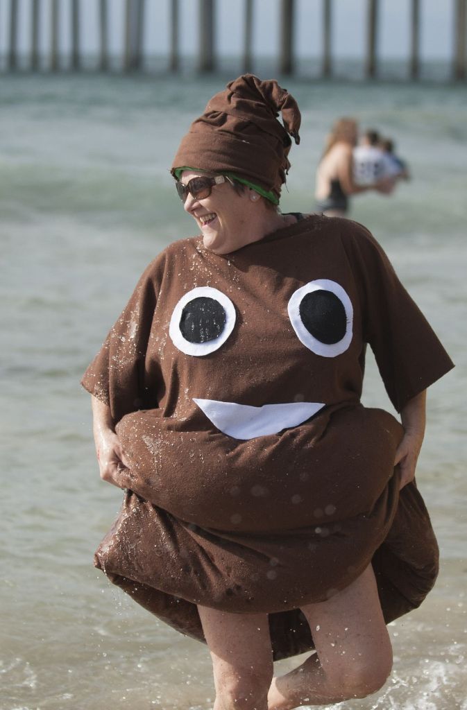 Im Emoji-Kostüm kommt diese Frau aus dem ungefähr 13 Grad Celsius kalten Wasser am Huntington Beach (USA). Das Neujahrsschwimmen wird hier „Polar Plunge“ genannt.