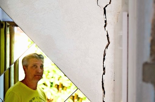 Antonio La Marra kontrolliert regelmäßig die bis zu drei Zentimeter breiten Risse in seinem Haus, die sich vom Keller    bis unter das Dach ziehen. Foto: factum/Weise