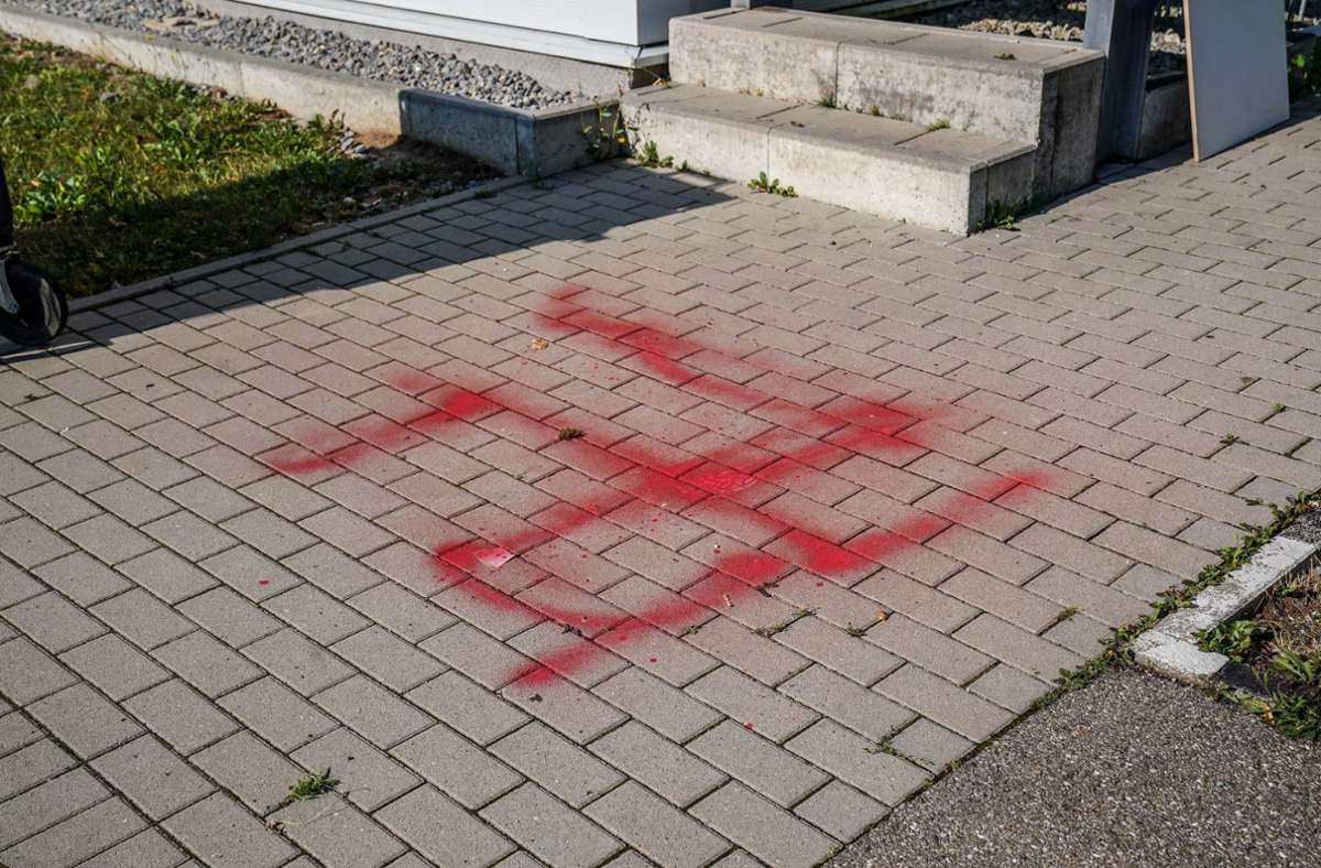 Die Symbole sind in roter Farbe an einem Zaun, Hausfassaden und Gehwegen angebracht worden.