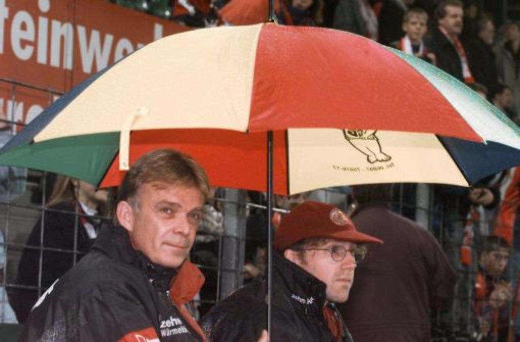 ... SC-Trainer Volker Finke (links) unterm Regenschirm bedröppelt drein. In den darauffolgenden Jahren gestalten sich die Duelle der beiden Mannschaften ausgeglichen, mal ...