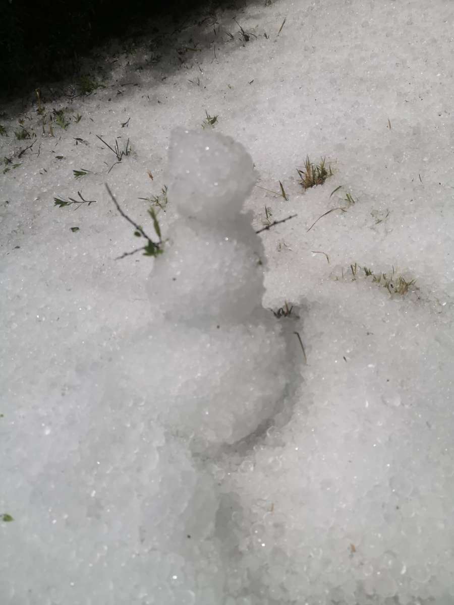 Ein kleiner Schneemann aus Hagelkörnern vor der Festhalle in Flacht.
