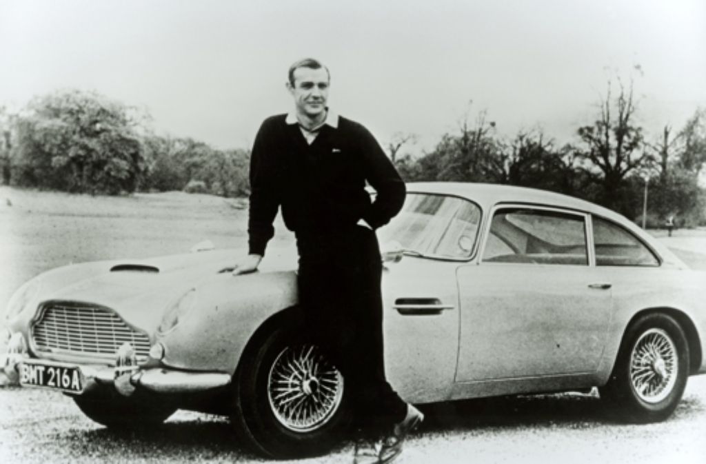 Fällt irgendwo der Name des britischen Autobauers Aston Martin, denken die meisten an James Bond. Hier Bond-Darsteller Sean Connery vor einem Aston Martin DB5.