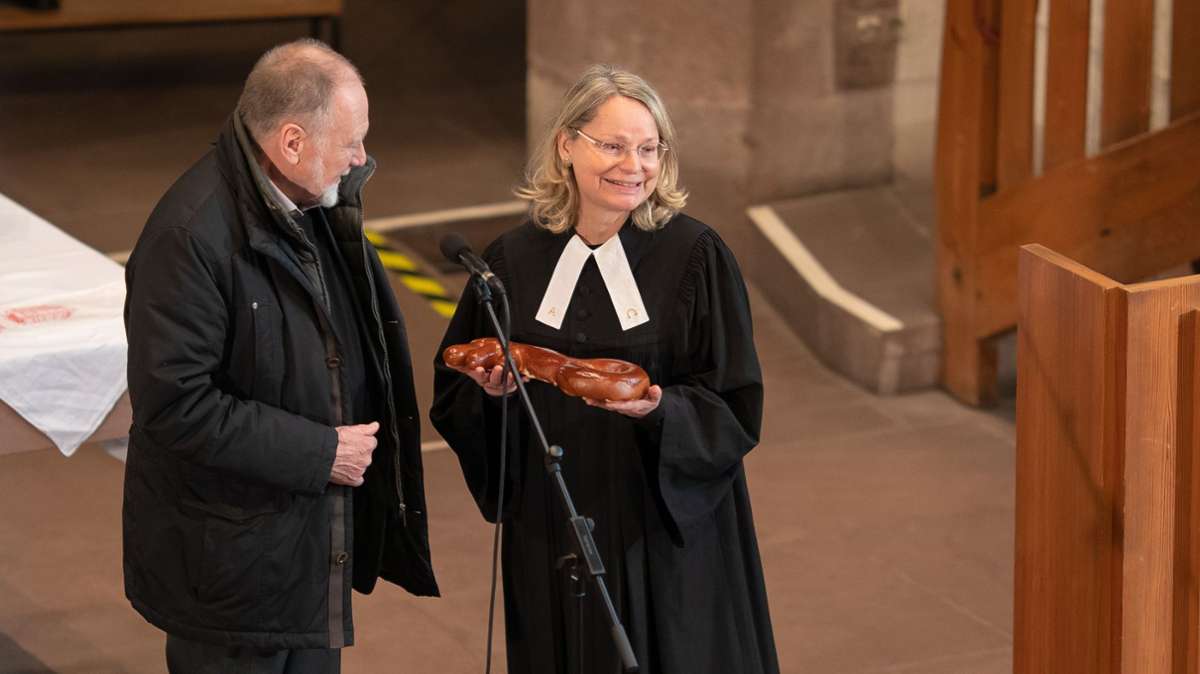 Pfarrerin Gabriele Ehrmann erhält während der Eröffnung der 30. Vesperkirche symbolisch den „Schlüssel zur Kirche“ von Bernhard Opitz, dem Leiter des Kirchengemeinderats.