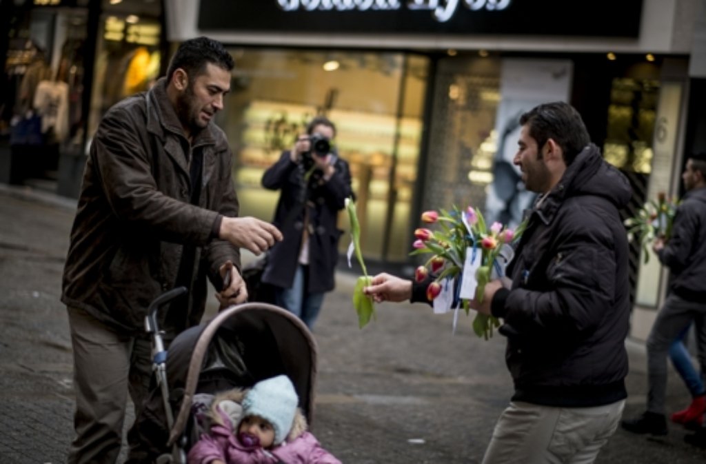 Syrische Flüchtlinge aus Stuttgart nutzten die Aktion, um mehr als 400 Blumen an die Teilnehmer und Passanten zu verschenken.