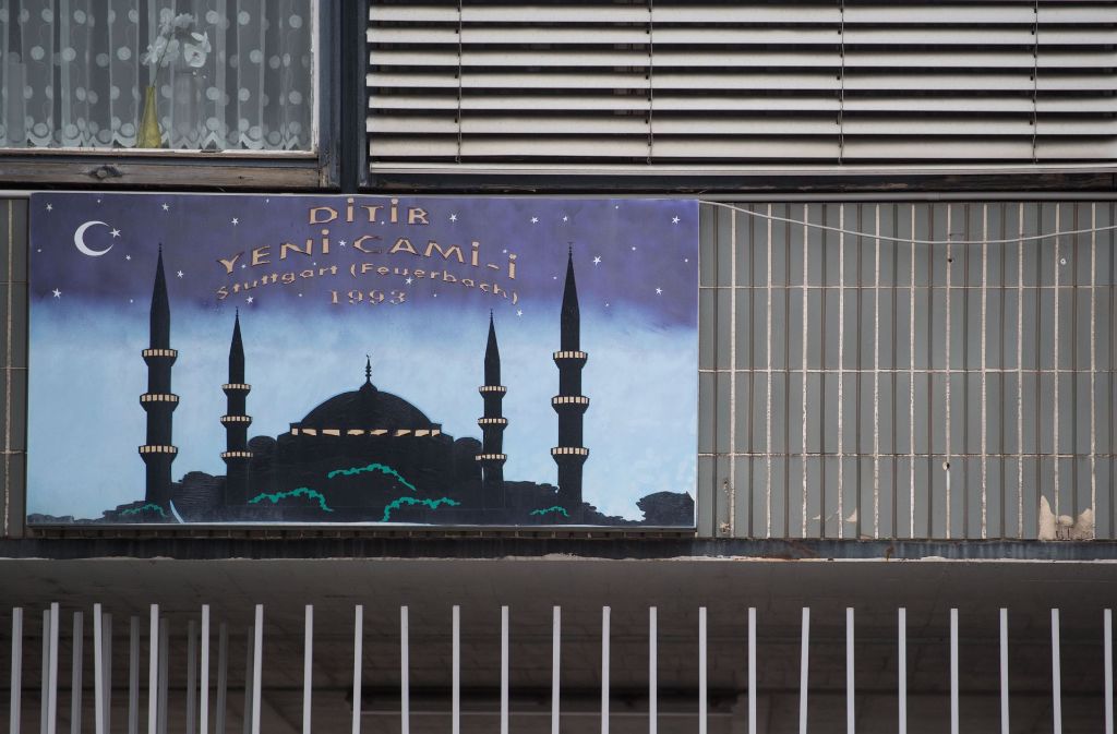 Ein Schild weist an der Außenfassade eines ehemaligen Fabrikgebäudes auf die Ditib Yeni Camii Moschee hin.