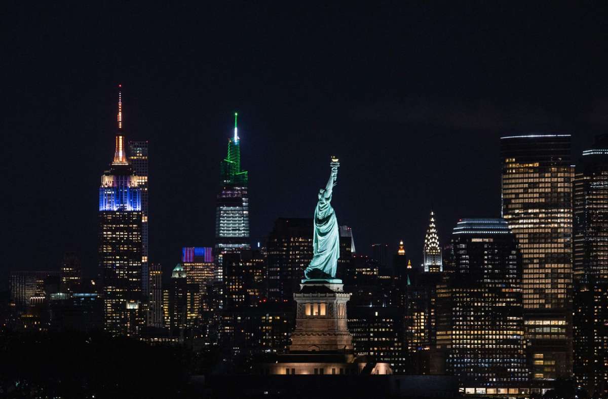 Das Wahrzeichen New York City, die Freiheitsstatue, leuchtet über dem Big Apple.