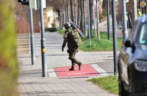 Ein Polizist des SEK trägt nach dem Einsatz in Reutlingen einen schusssicheren Schild zu einem Einsatzfahrzeug des Kommandos. Foto: Kevin Lermer/7aktuell.de