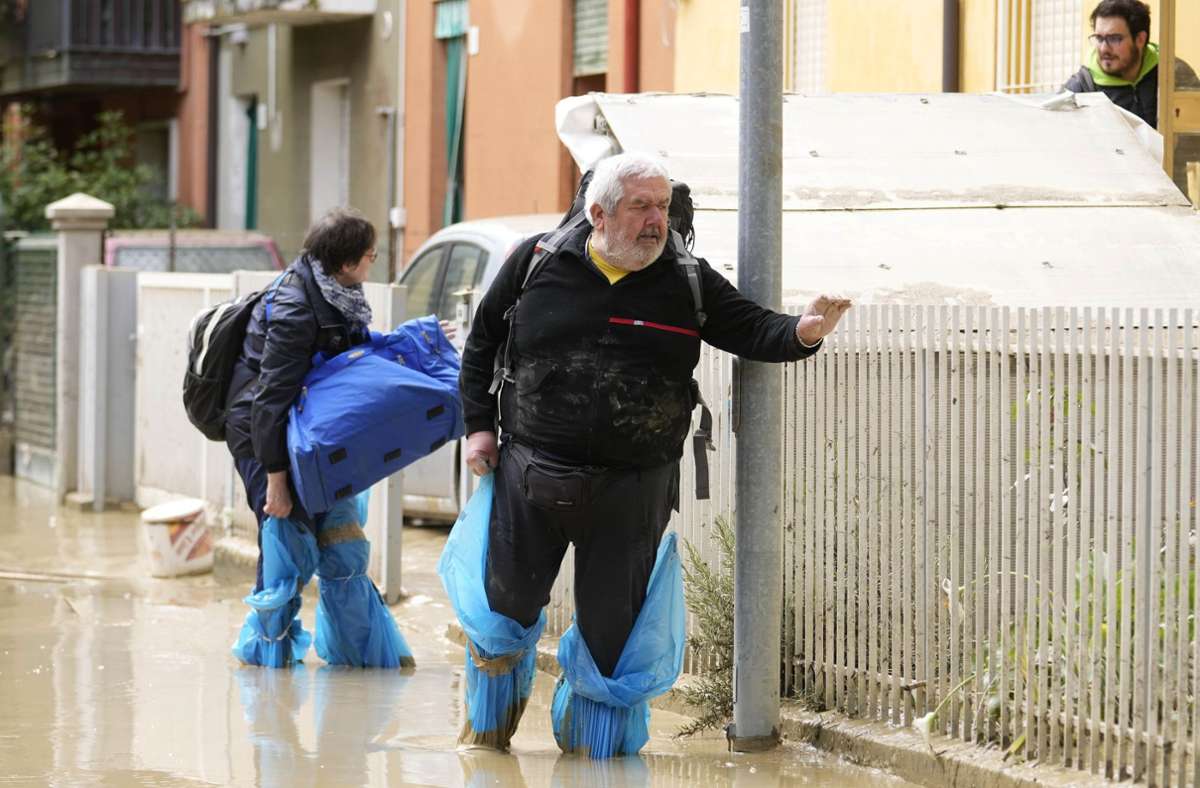 Faenza: Menschen gehen auf einer überfluteten Straße.