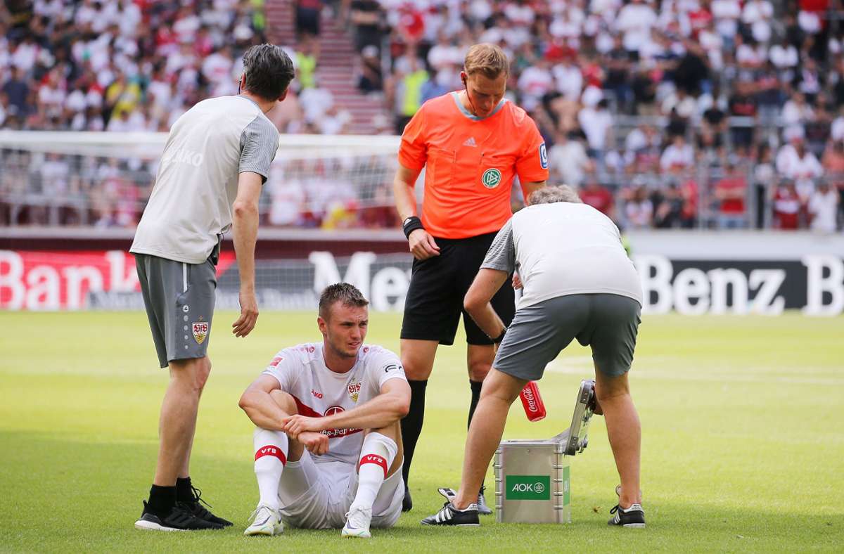 Sasa Kalajdzic (VfB) sitzt angeschlagen am Boden und muss ausgewechselt werden.