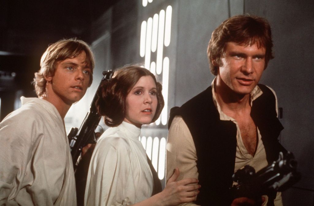 Harrison Ford als Han Solo (rechts) mit Mark Hamill als Luke Skywalker und Carrie Fisher als Leia Organa in „Star Wars“ (1977)