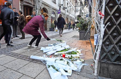 Eine Frau legt an einem Tatort in Straßburg Blumen nieder. Direkt nach dem Terror in Straßburg riegelte die Polizei  die Grenze bei Kehl ab . . . Präsident Foto: AFP