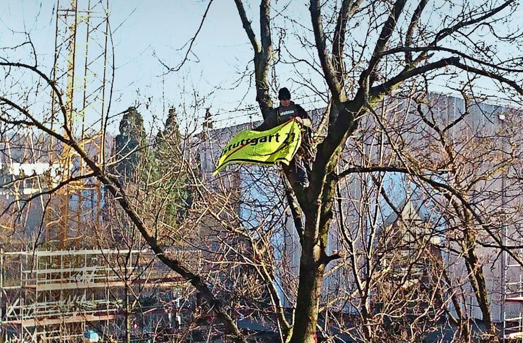In etwa zehn Metern Höhe entrollt der Aktivist ein Banner gegen das Bahnprojekt. Foto: Andreas Rosar