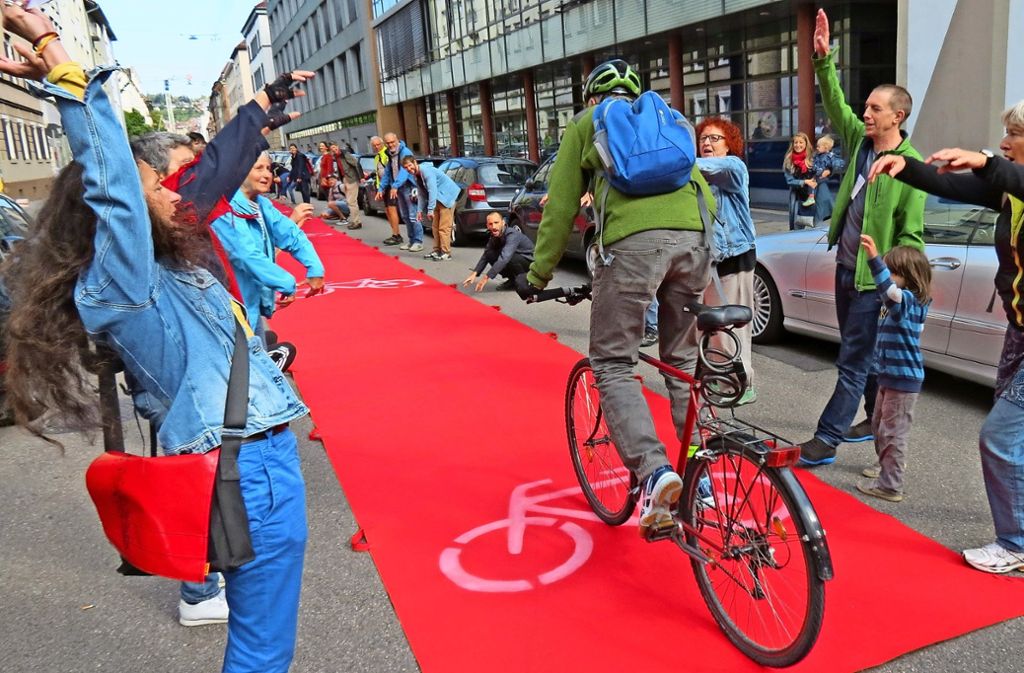 Fahrradfahrer dürfen drüberfahren, Autos müssen unten durch:  Rund 50 Menschen sind  mit einem 50-Meter-Teppich durch den Stuttgarter Westen gezogen. Foto: Julia Bosch