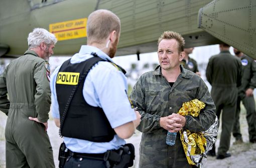 Peter Madsen (rechts) am 11. August im Gespräch mit einem Polizisten nach seiner Rettung aus dem gesunkenen U-Boot. Foto: dpa