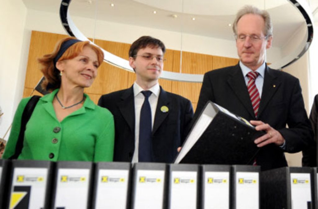 Wolfgang Schuster (r) nimmt am Montag im Rathaus in Stuttgart insgesamt 35.600 Unterschriften gegen Bahnprojekt Stuttgart 21 entgegen.