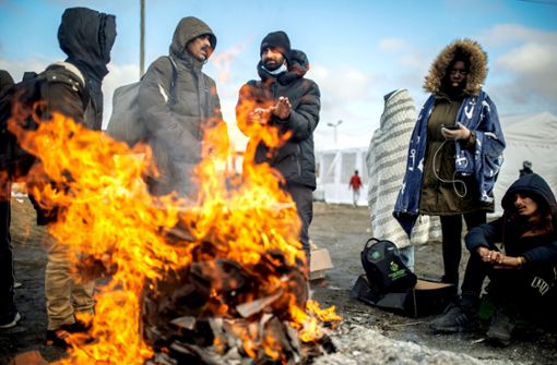 Menschen wärmen sich am Grenzübergang in Medyka, Polen (Symbolbild). Foto: dpa/Alejandro Martínez Vélez
