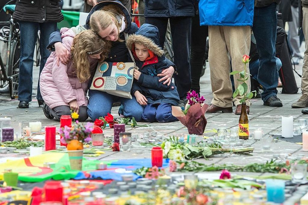 Eine Frau trauert vor der Börse am Place de la Bourse mit ihren Kindern um die Verstorbenen der Anschläge.