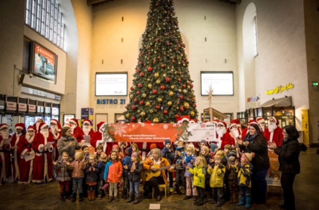 Gruppenfoto vor dem riesigen Weihnachtsbaum im Bahnhof.