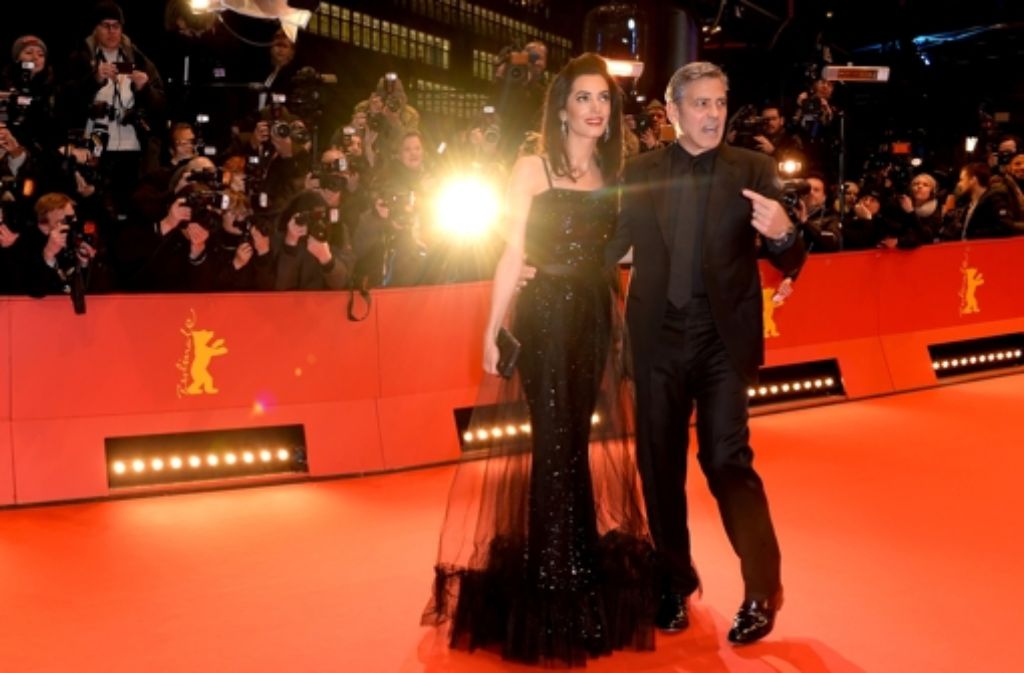 Amal Clooney begleitete ihren Mann George Clooney auf die Berlinale. Die Juristin zog mit ihrem schwarzen Kleid, das 1981 von Yves Saint Laurent entworfen wurde, alle Blicke auf sich. Unsere Fotostrecke zeigt, dass auch andere Stars mit ihren Roben auf dem roten Teppich glänzten.