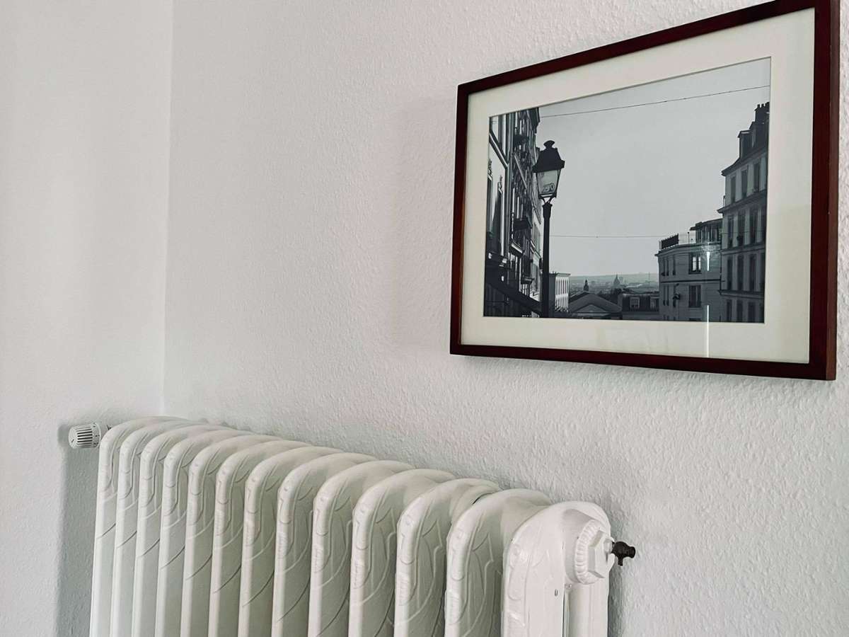 Ein weiteres Highlight der Altbauwohnung: die alten Heizkörper, perfekt kombiniert mit einem Foto aus Paris.