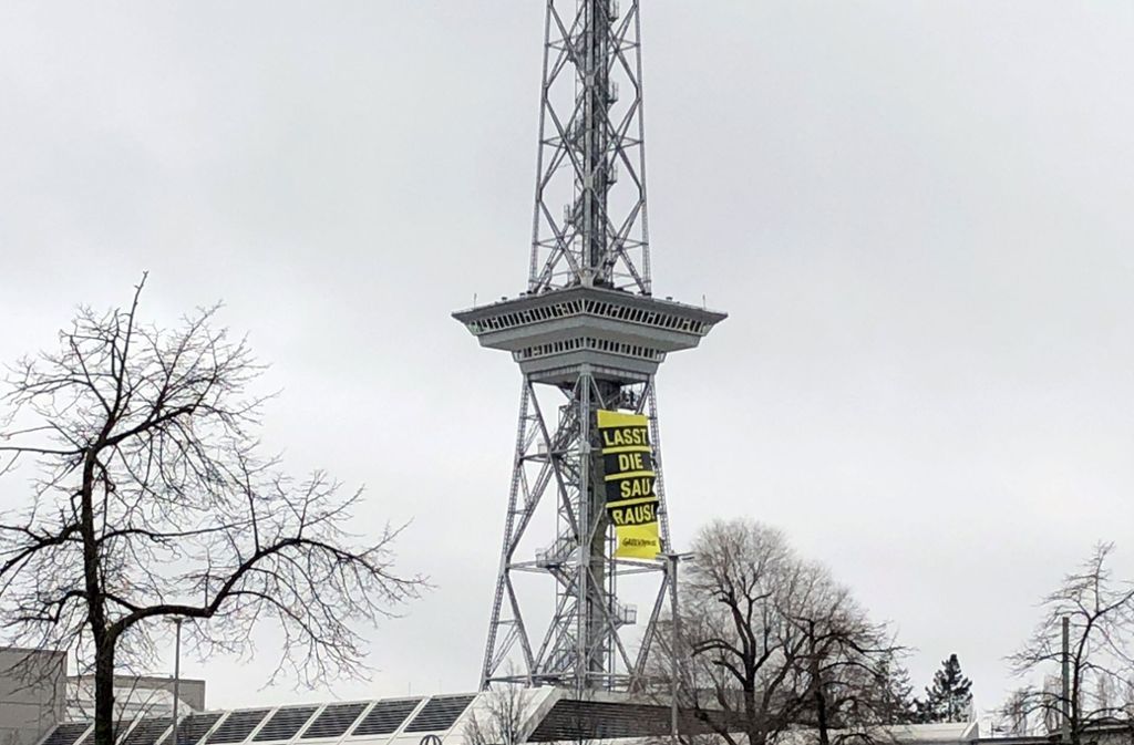 Die Aktivisten hängten ein Plakat an einen Turm ...