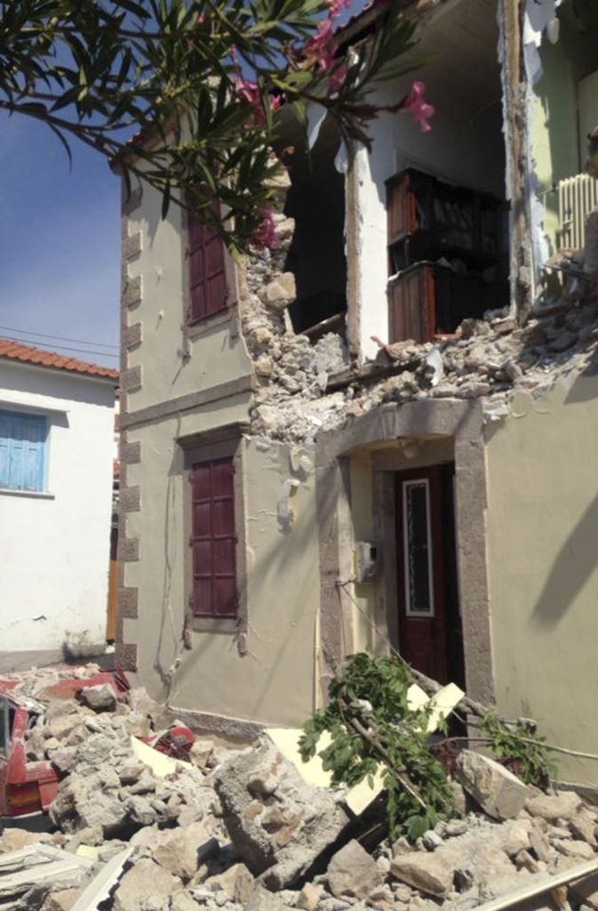 Steine und Schutt liegen in der Kleinstadt Vrisa in Griechenland vor einem stark beschädigten Haus.