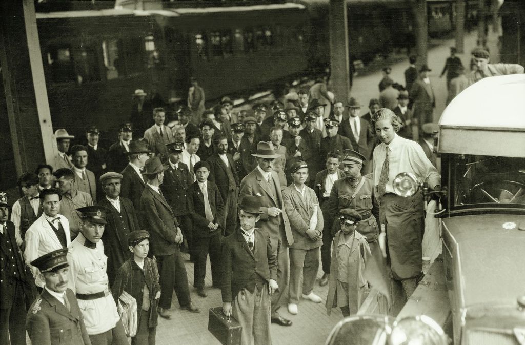In Istanbul müssen die Wagen vorübergehend auf den Zug verladen werden. Clärenore Stinnes (rechts) ist gekleidet wie ein Mann: Hemd, Krawatte, Hose.