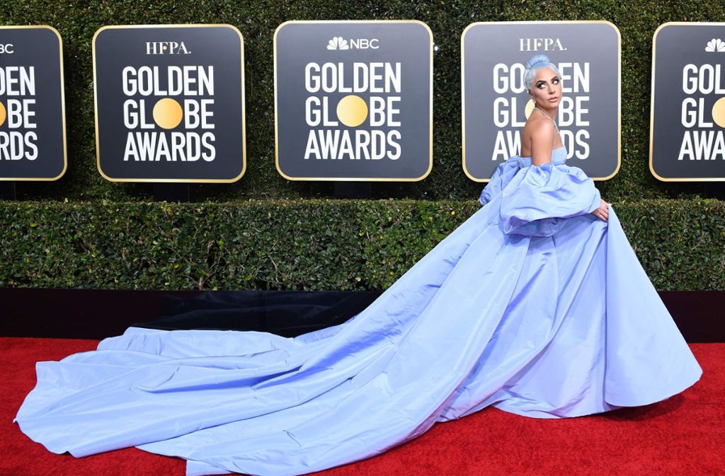So kennen wir Lady Gaga: in einer überkandidelten eisblauen Robe von Valentino gewandet, schritt sie wie eine Rokoko-Dame über den roten Teppich. Passend dazu hat sie sich ihre Haare im selben Farbton gefärbt.