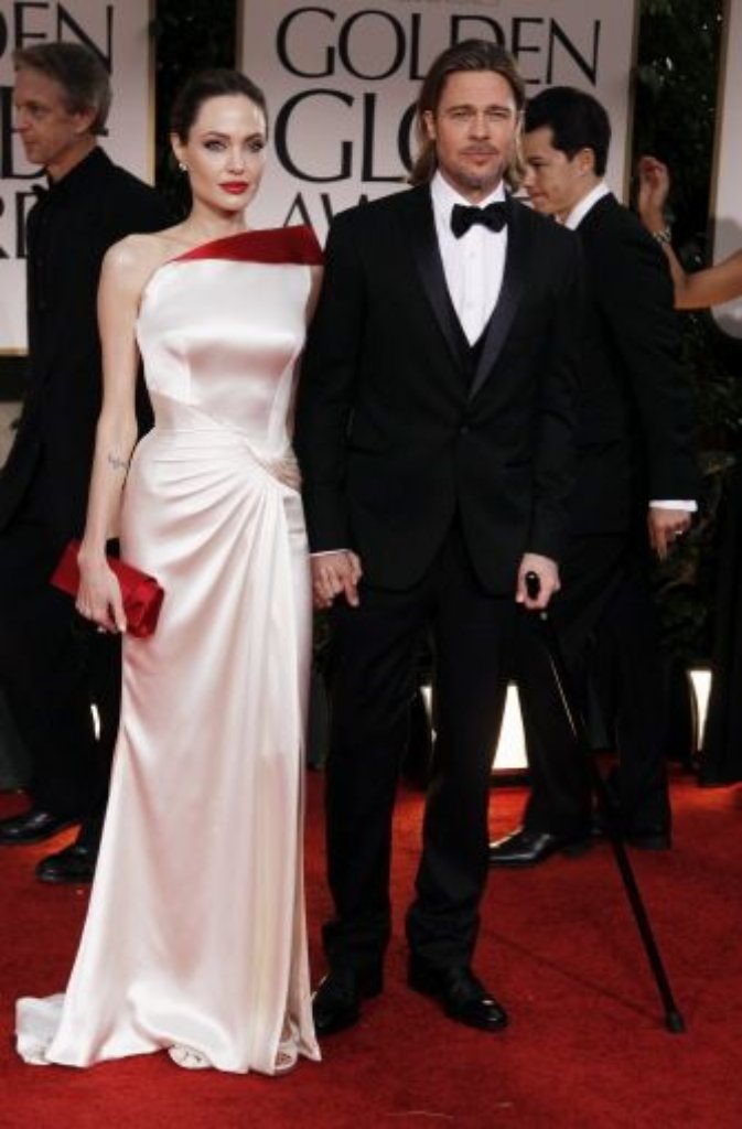 Er am Stock, sie in einem weiß-roten Traum von Versace: Angelina Jolie und Brad Pitt.