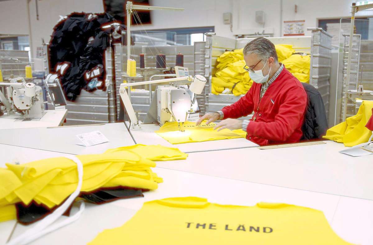 In die Produktion geschaut: Ein Trigema-Näher arbeitet an den quietschgelben Shirts mit dem Aufdruck "The Länd".