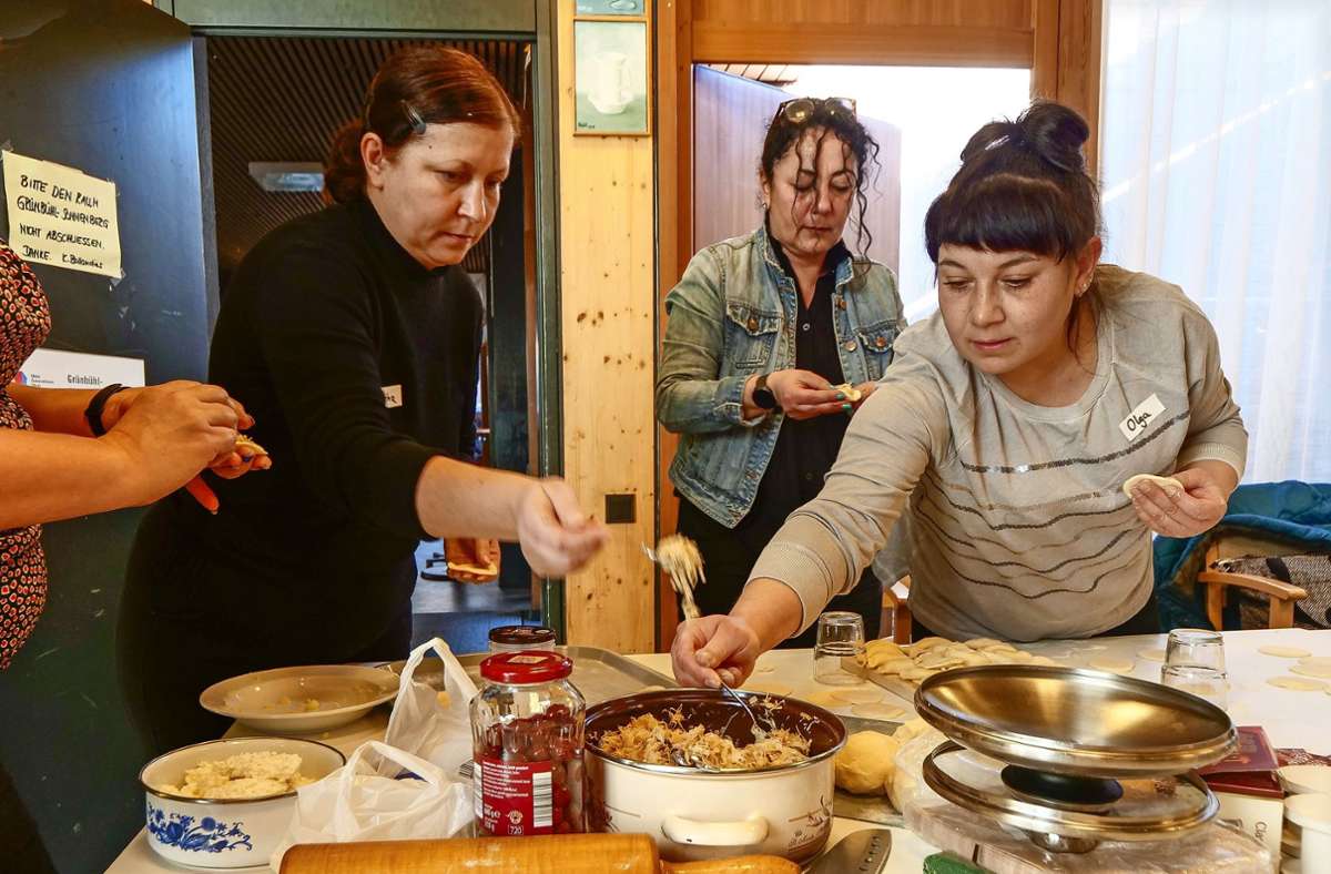 Serap Balles (Im Hintergrund) bereitet mit den Frauen die Füllungen vor. In der Küche (Foto rechts) schöpfen Viktoria Holota (links) und Olena Iastrebynska die Wareniki ab.