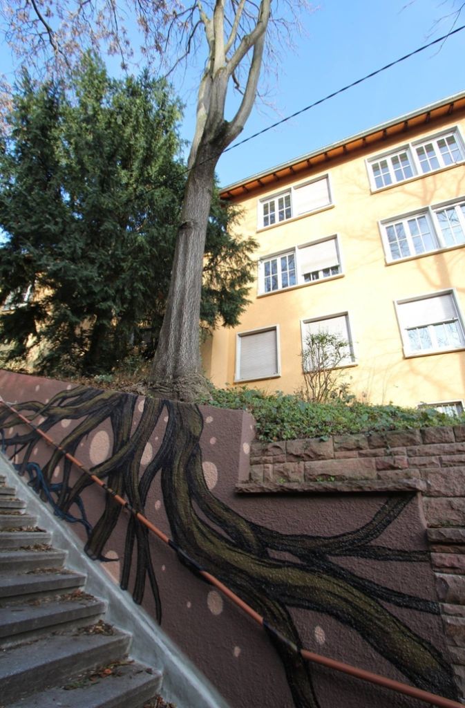 Stuttgarter Künstler Jeroo lässt die Wurzeln eines Baumes in eine Mauer hineinwachsen.