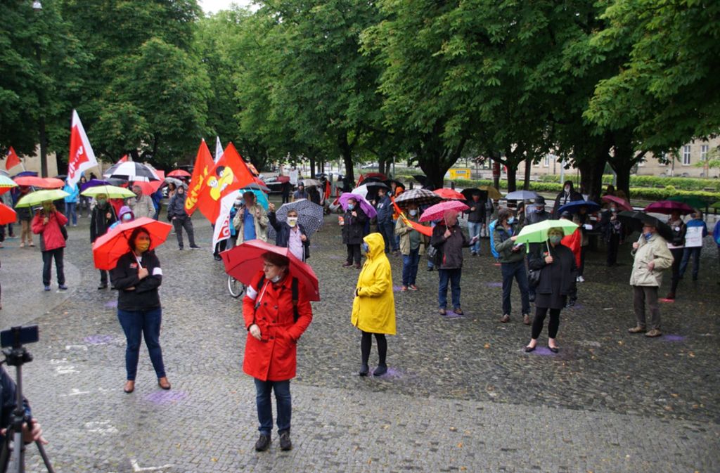 Trotz strömenden Regens haben sich mehrere Gewerkschaften, andere Initiativen sowie Privatpersonen auf dem Karlsplatz versammelt.