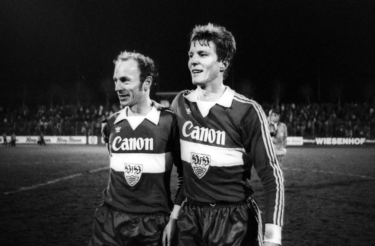 Erwin Hadewicz (li.) und Karlheinz Förster vom VfB Stuttgart mit bekanntem Sponsorennamen über dem Brustring. Das Wappen ist 1980 in der Mitte des Trikots des platziert. Geschmacksache ist auch der etwas verspielte Kragen.