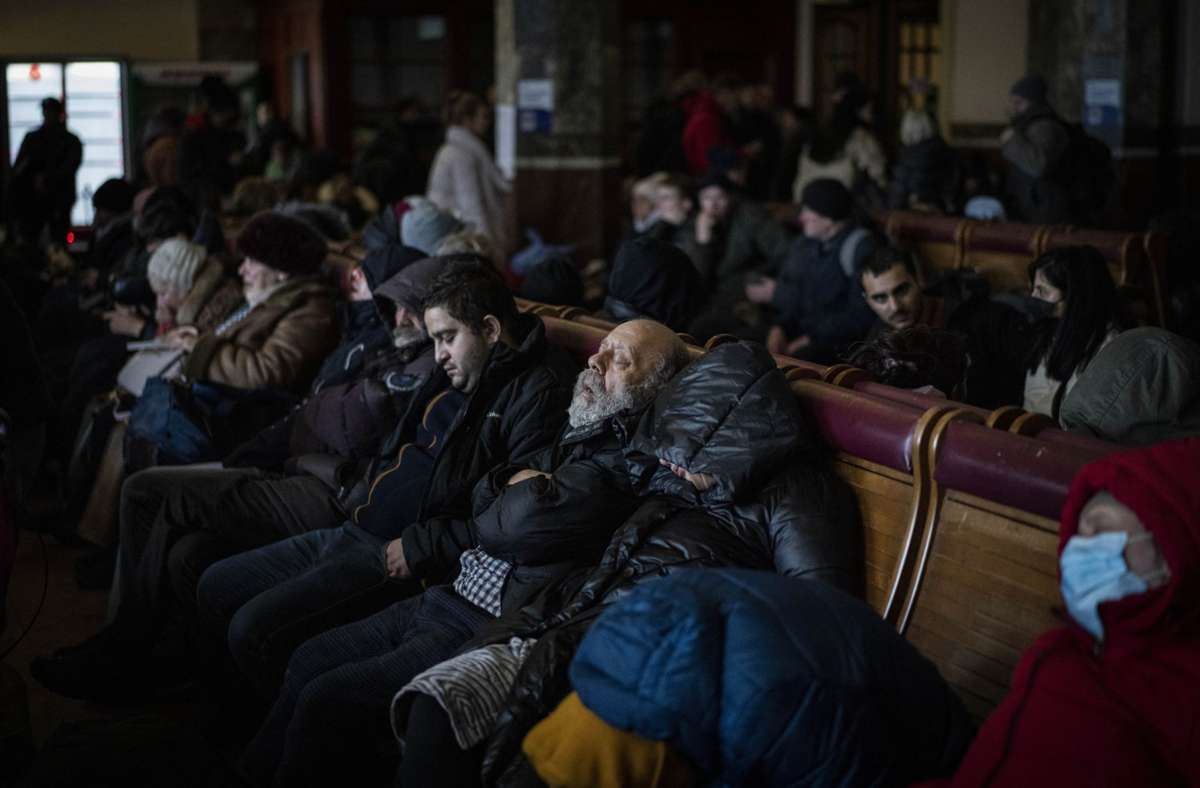 Menschen, die versuchen, aus der Ukraine zu fliehen, schlafen in einem überfüllten Bahnhof.