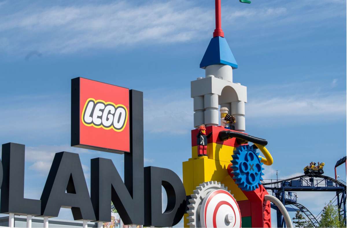 Neben dem Logo am Eingang zum Legoland ist eine Achterbahn zu sehen.