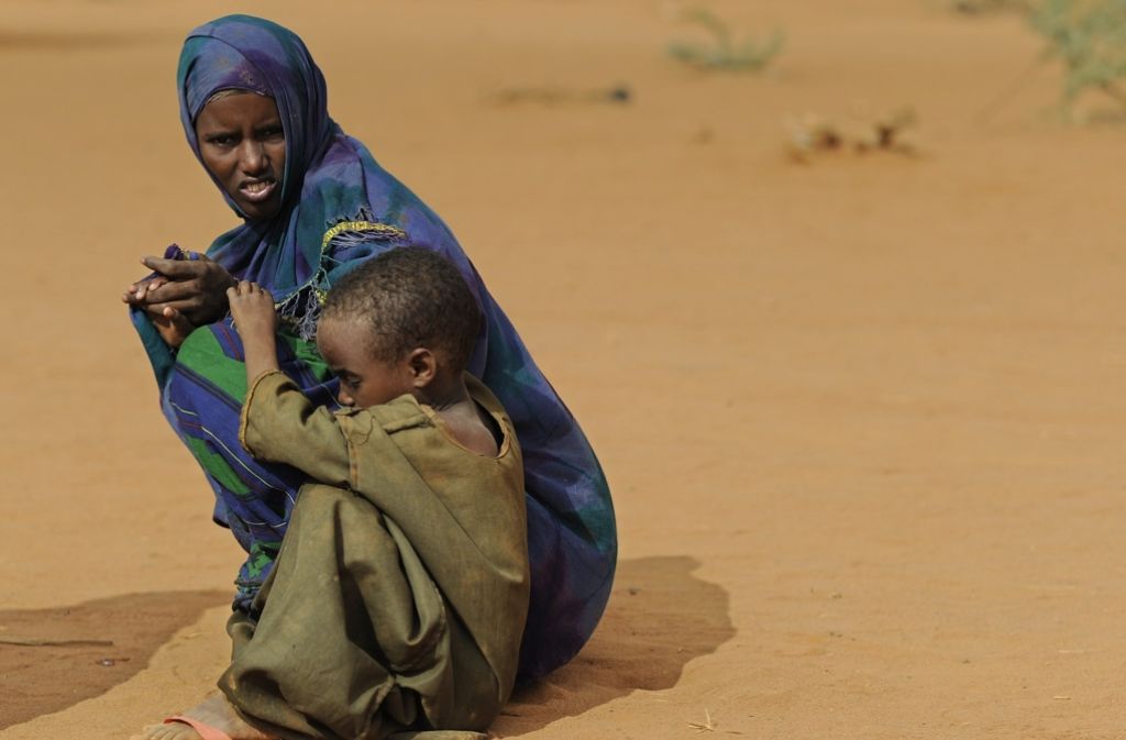 Kenia: Eine Frau hockt mit ihrem Kind im Flüchtlingslager Dadaab im Nordwesten des Landes im Wüstensand.