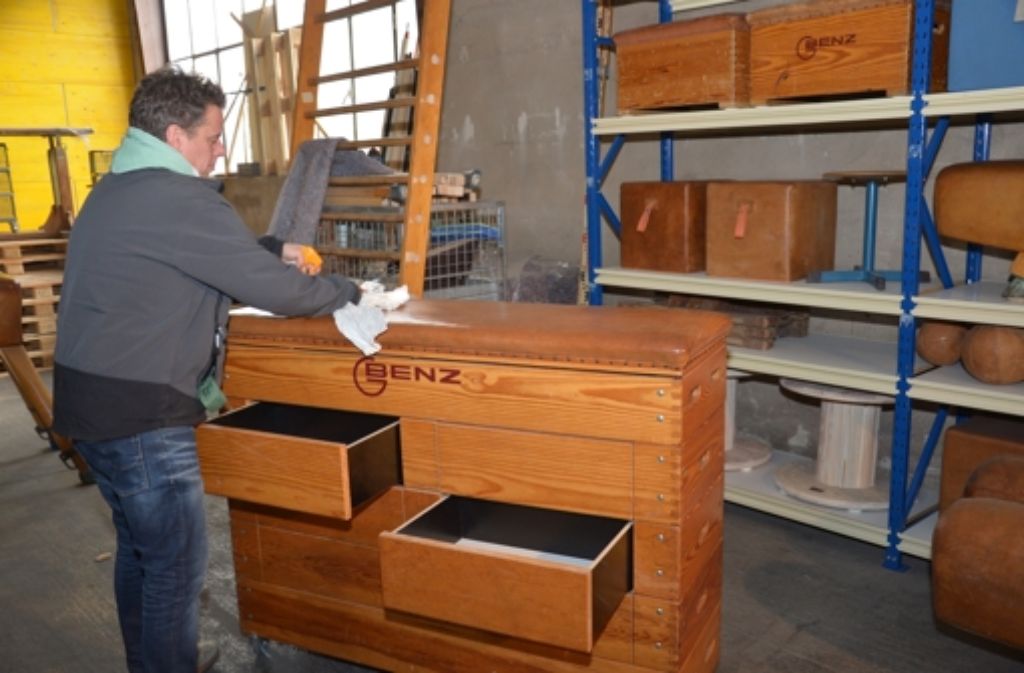 Das Holz muss beim Upcycling ganz neu aufbereitet werden. Zur Pflege putzt Andreas Gröbel das Material mit einem Spray.