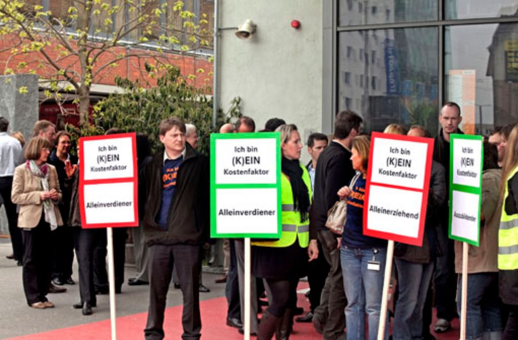 Hoffnungslosigkeit und Trauer: ein Mercedes-Benz-Bank-Mitarbeiter protestieren vor dem Stuttgarter Theaterhaus gegen die Verlagerung und den Abbau von Stellen.